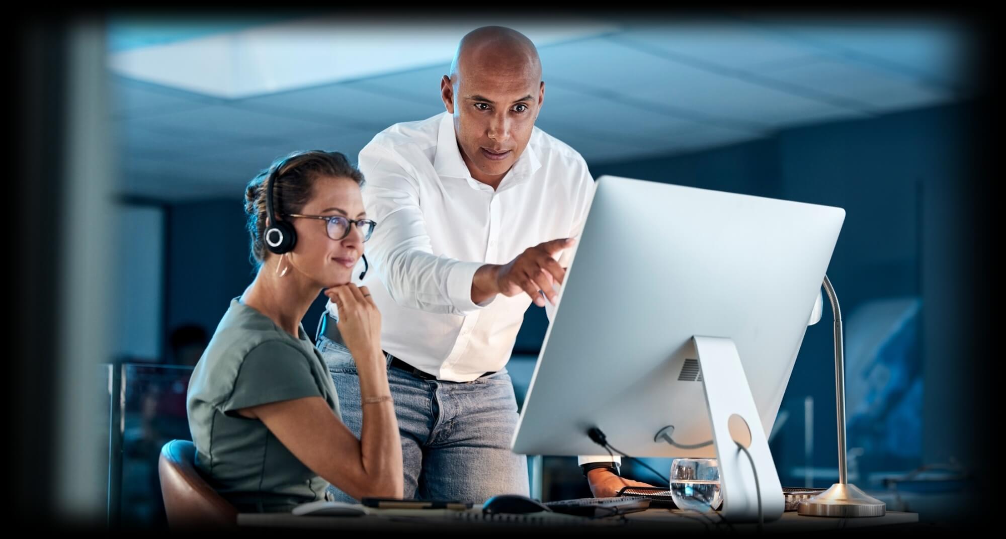 Two employees looking at a computer monitor