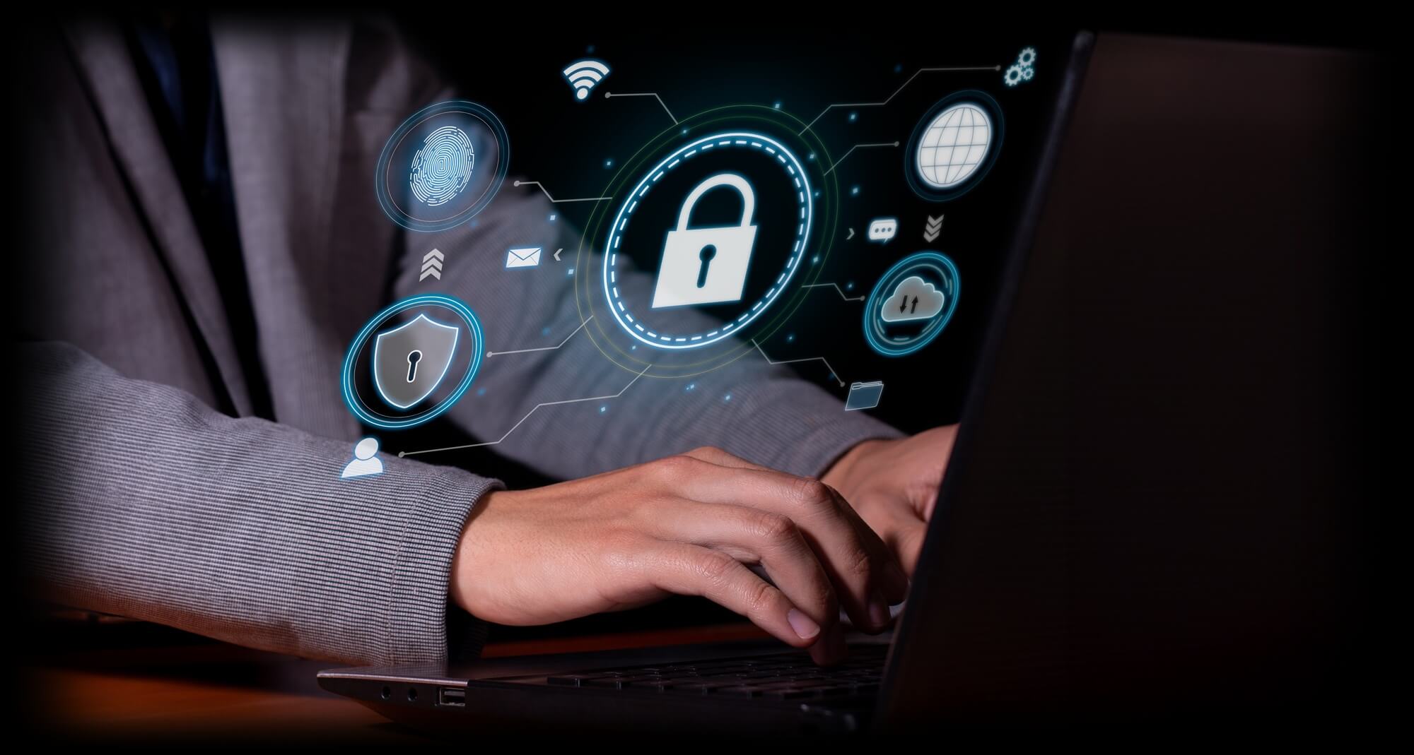 Someone typing in laptop with cybersecurity symbols
